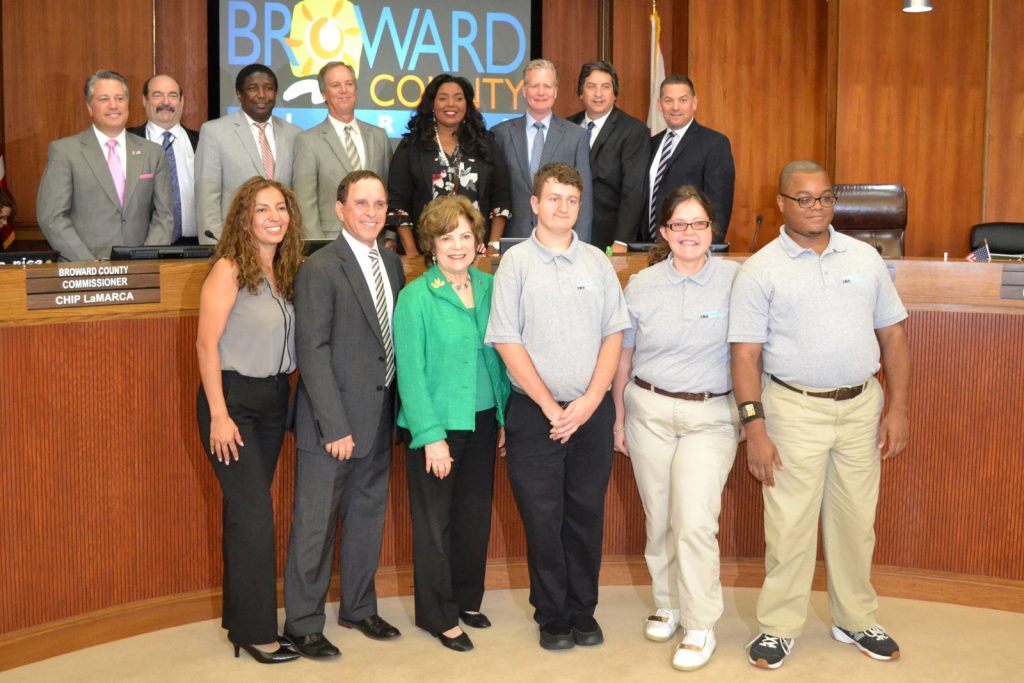 group of adults posing for photo at broward county meeting