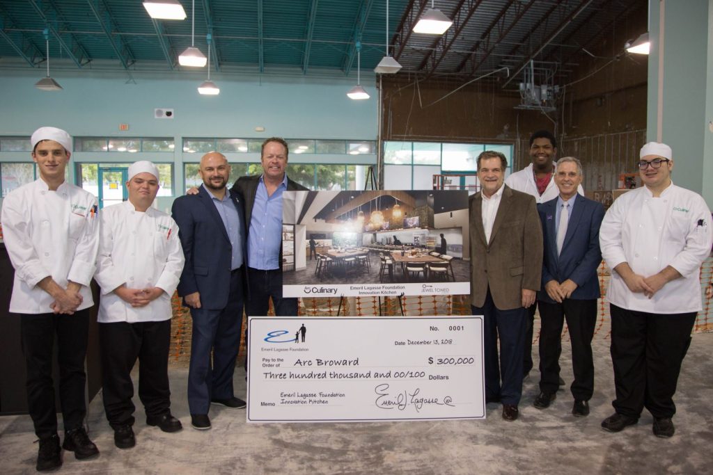several arc broward team members accepting giant check