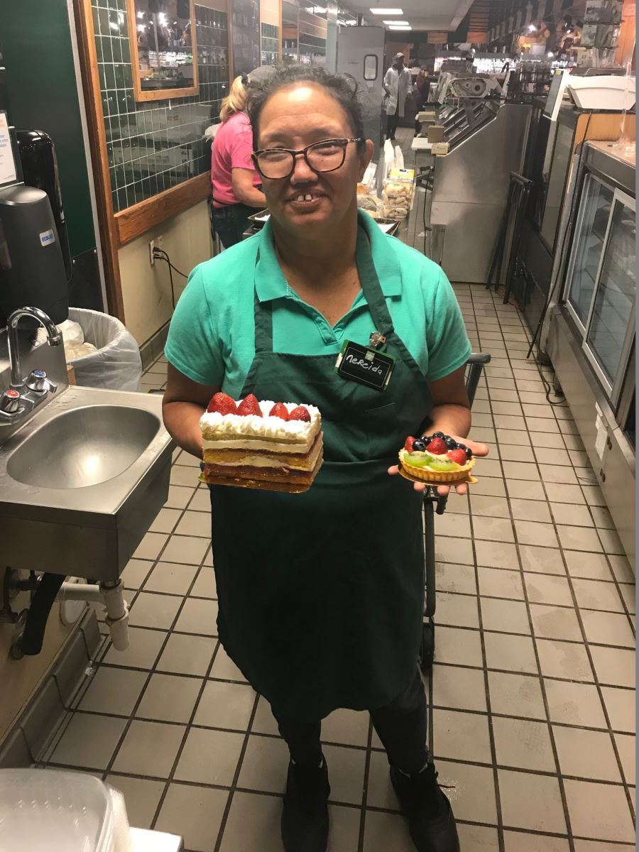 Nereida standing in kitchen holding desserts