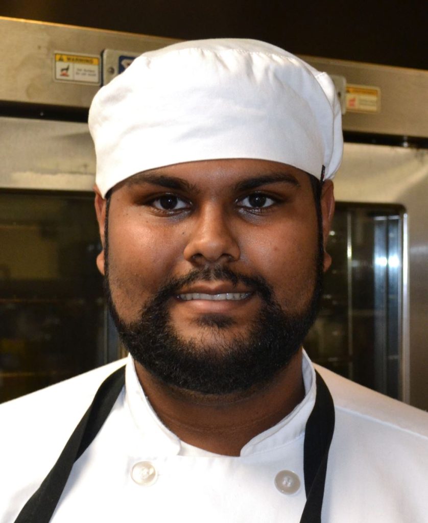 man in chefs uniform posing for photo
